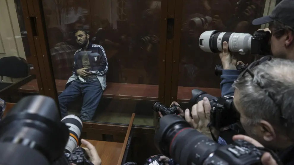Moscow (Russian Federation), 24/03/2024.- Photographers take pictures of a suspect in the shooting attack on the Crocus City Hall concert venue sits inside a defendant's enclosure during a hearing on pretrial restrictions at Basmanny district court, in Moscow, Russia, 24 March 2024. At least 137 people were killed and more than 180 hospitalized after a group of gunmen attacked the concert hall in the Moscow region on 22 March evening, Russian officials said. Eleven suspects, including all four gunmen directly involved in the terrorist attack, have been detained, according to Russian authorities. (Terrorista, Atentado terrorista, Rusia, Moscú) EFE/EPA/SERGEI ILNITSKY