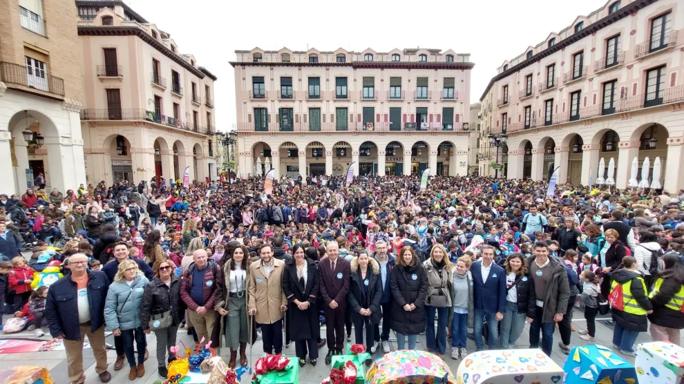 Imagen de las autoridades en primer plano y detrás los más de 3.600 escolares participantes en la Mini Marcha Aspace Huesca.