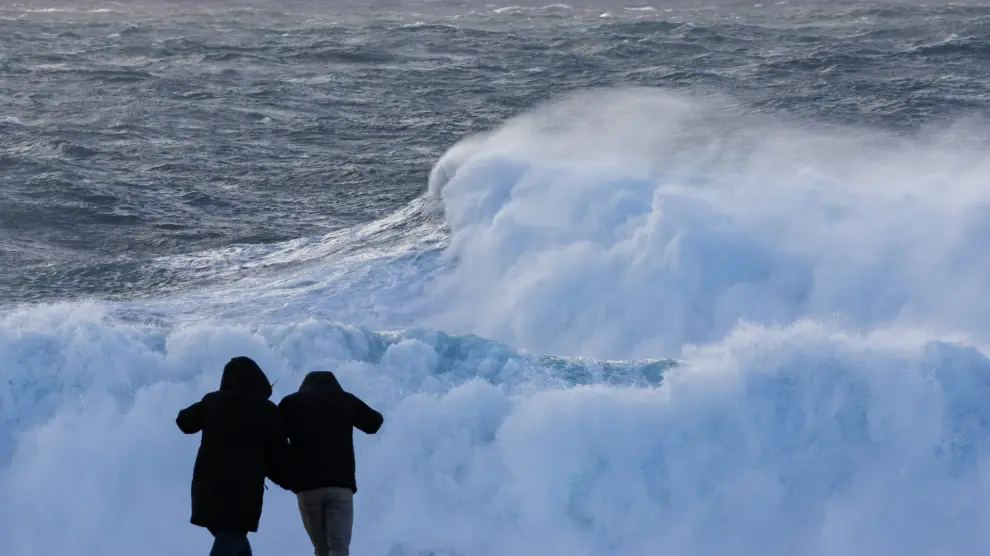 Dos turistas observan el oleaje en la costa de Muxía (Galicia), donde estos días festivos están marcados por la borrasca Nelson.