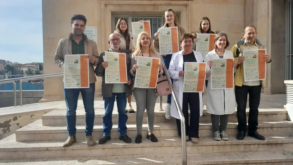 Representantes de los consejos de salud de Teruel y de asociaciones vinculadas a la prevención de enfermedades posan con el cartel de las actividades en la puerta del centro de salud Centro.