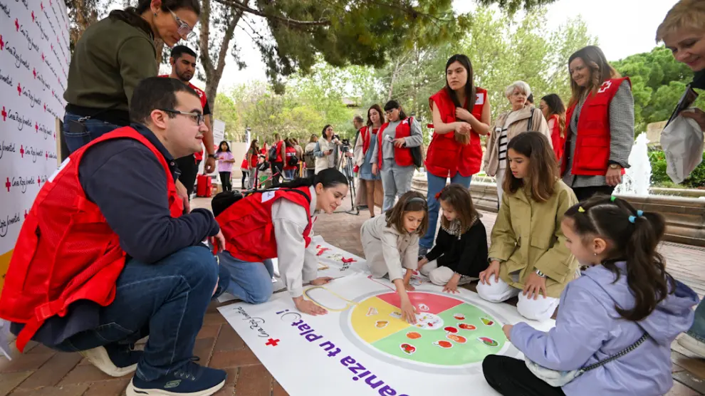 Unas niñas participan en la actividad sobre alimentación consciente que ha organizado Cruz Roja en la plaza de Los Sitios