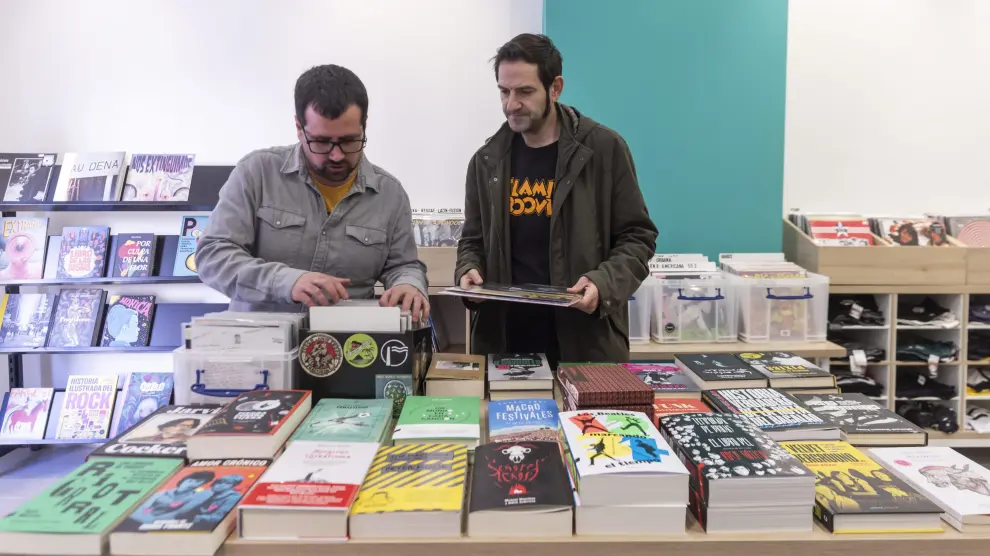César Cartiel (a la izquierda) con un cliente, en la nueva ubicación de su tienda de discos y libros, Picaraza.