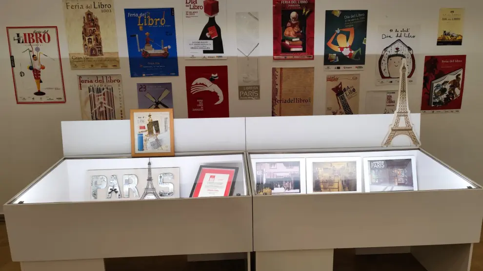La doble vitrina de los premios y los escaparates; arriba una amplia selección de carteles del día y la feria del libro de Zaragoza.