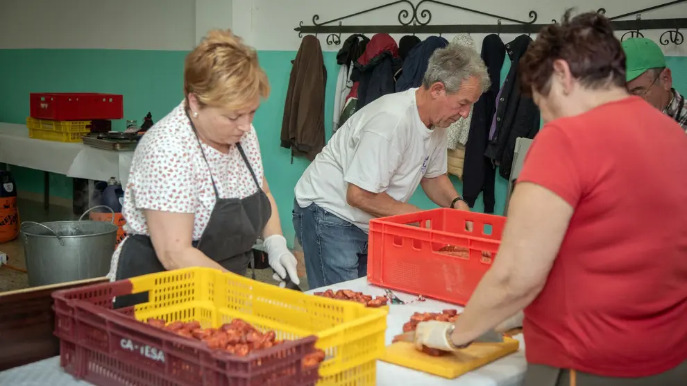 Mujeres de Ruesca ayudando a José Manuel Gil a preparar la tradicional comida popular con las judías como protagonistas.