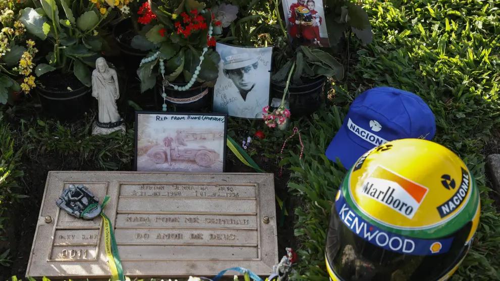 Un casco de piloto, fotografías y arreglos florales, en la tumba del automovilista brasileño Ayrton Senna este miércoles, cuando se conmemoran tres décadas de su fallecimiento, en el cementerio de Morumbi en Sao Paulo (Brasil).
