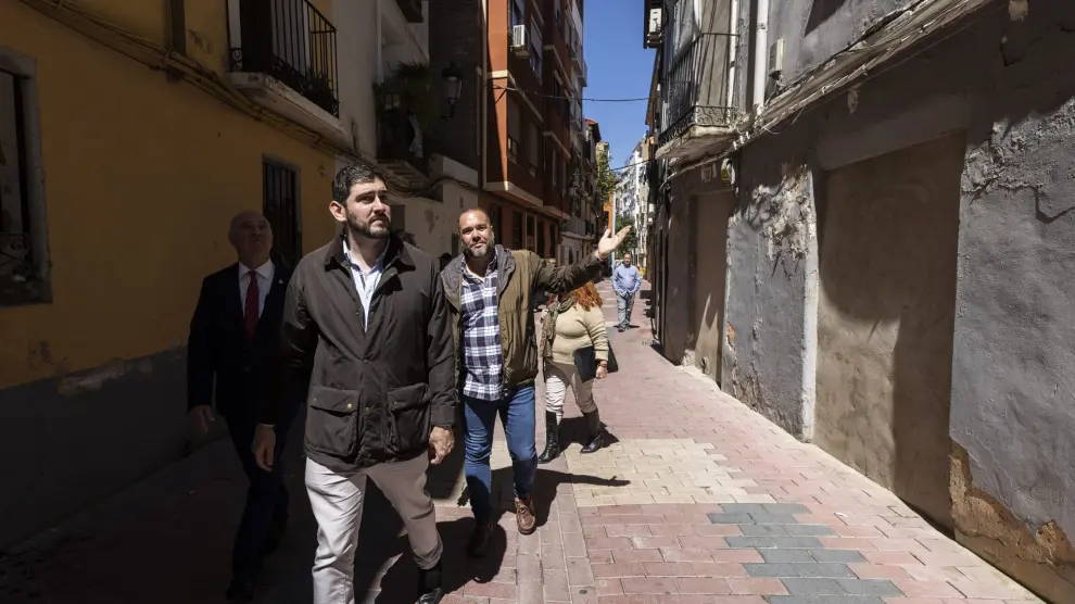 Un vecino enseña una casa tapiada al vicepresidente aragonés, Alejandro Nolasco, en su visita al sector Zamoray-Pignatelli de Zaragoza, uno de los más afectados por ocupaciones de pisos.