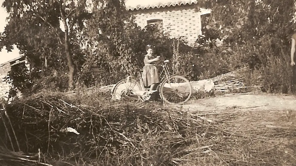 Una niña teruelina posa delante de la torre de Albelda a la que se trasladó con su familia.