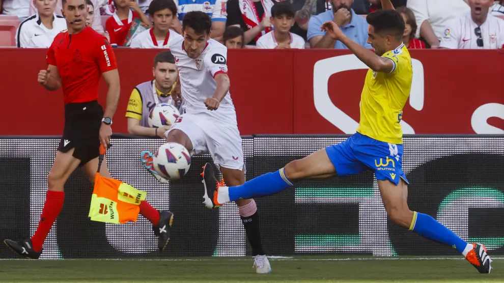 El defensa del Sevilla Jesús Navas pelea un balón con el centrocampista del Cádiz Robert Sobrino.
