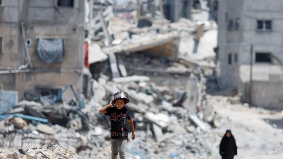 Palestinos destrozan entre edificios destruidos tras el último ataque del ejército israelí.
