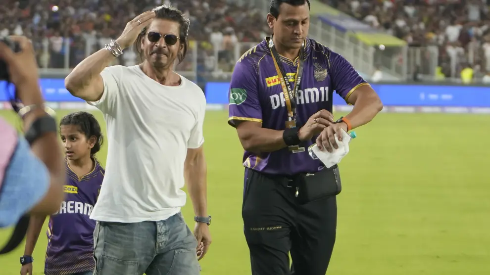 Bollywood actor and Kolkata Knight Riders co-owner Shah Rukh Khan, left, reacts to the spectators after his team's win in the Indian Premier League qualifier cricket match against Sunrisers Hyderabad in Ahmedabad, India, Tuesday, May 21, 2024. (AP Photo/Ajit Solanki)