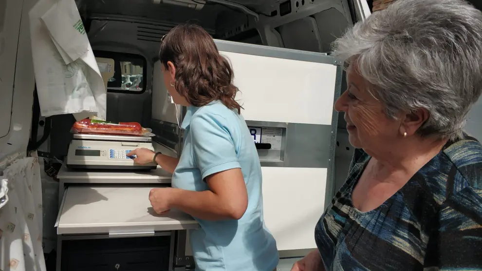 Isabel pesa el producto en el interior de la furgoneta Casa Marcelina