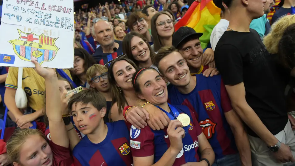 Barcelona's Mariona Caldentey holds her medal posing with fans after winning the women's Champions League final soccer match between FC Barcelona and Olympique Lyonnais at the San Mames stadium in Bilbao, Spain, Saturday, May 25, 2024. Barcelona won 2-0. (AP Photo/Alvaro Barrientos) ASSOCIATED PRESS / LAPRESSE ONLY ITALY AND SPAIN