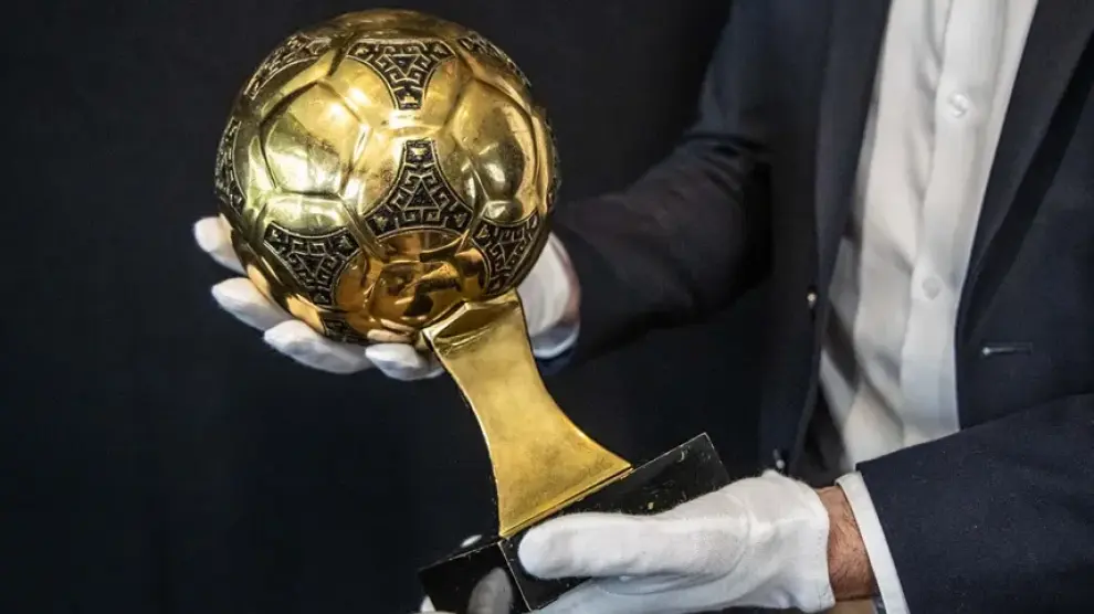 Francois Thierry, experto en deportes de la casa de subastas Aguttes, presenta el trofeo del Balón de Oro de Diego Maradona del Mundial de 1986.