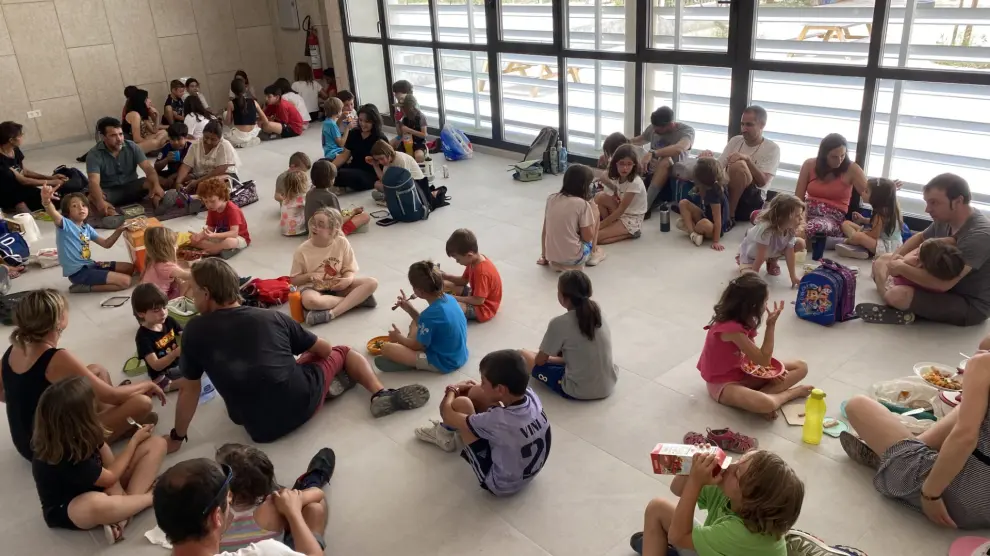 Medio centenar de personas comen de táper en la nueva sala polivalente del colegio de Peñaflor para reclamar el comedor escolar