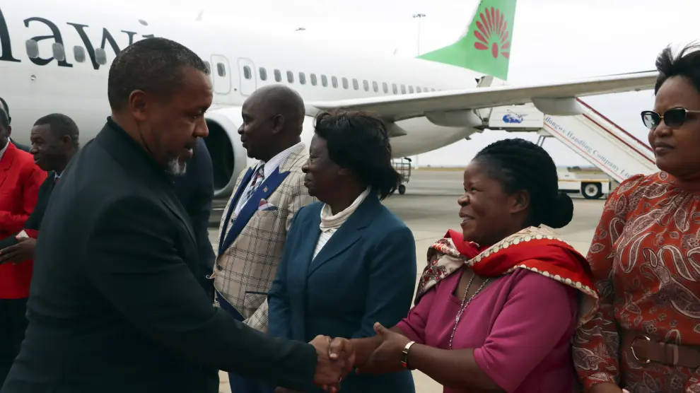 FILE - Malawi Vice President Saulos Chilima, left, greets government officials upon his return from South Korea in Lillongwe, Sunday, June 9, 2024. Malawi’s vice president and nine others have been killed in a plane crash, the country’s president said Tuesday. The wreckage of the military plane carrying Vice President Saulos Chilima was located in a mountainous area in the north of the country after a search that lasted more than a day. There were no survivors of the crash, Malawian President Lazarus Chakwera said. Chakwera made the announcement in a live address on state television. (AP Photo, File)