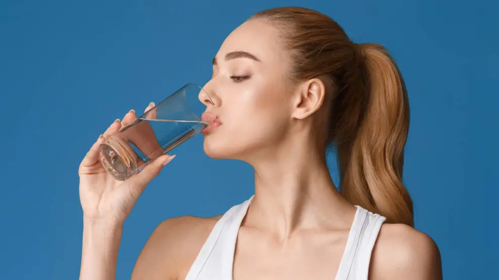 Una mujer bebiendo agua.