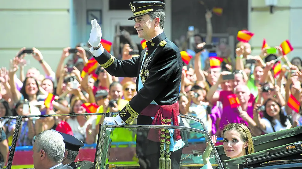 Don Felipe, convertido en Rey, saluda junto a la reina Letizia a quienes aquel 19 de junio de 2014 se echaron a las calles de Madrid para aclamarle
