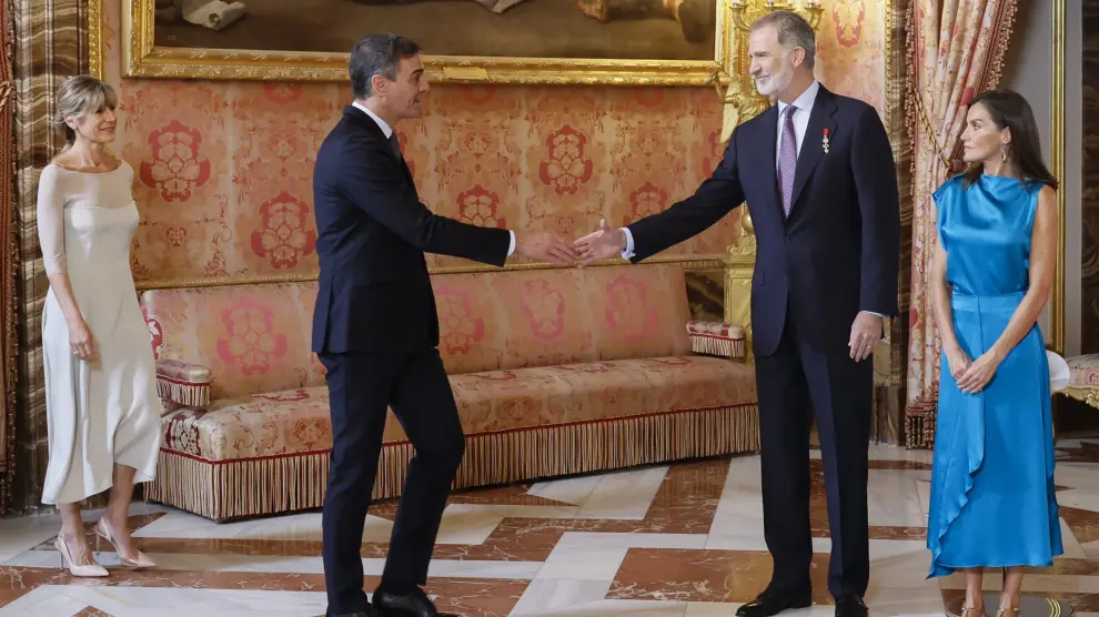 El rey Felipe VI (2d) y la reina Letizia (d) saludan al presidente del Gobierno, Pedro Sánchez (2i), y a su mujer Begoña Gómez (i) durante el besamanos en el Palacio Real en Madrid donde se conmemora el décimo aniversario del reinado de Felipe VI
