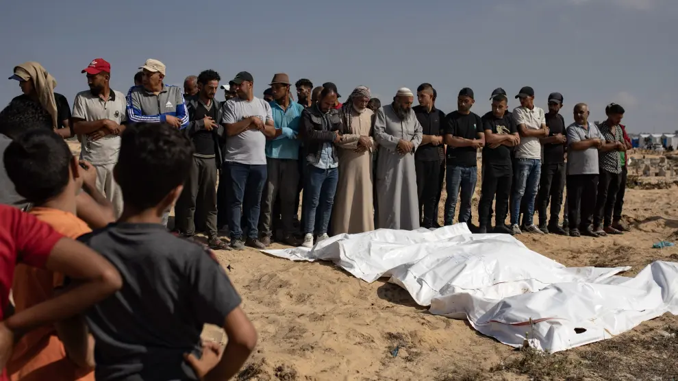 Un grupo de palestinos rezan por las víctimas de un ataque israelí en Khan Yunis