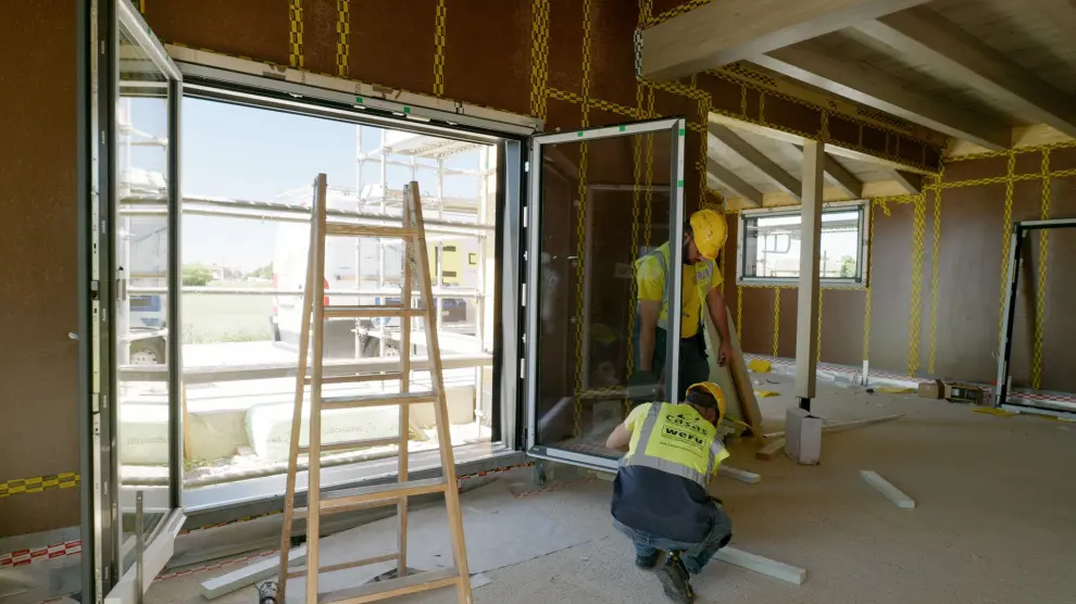 Los operarios trabajan en el interior de la vivienda passivhaus 'premium' en construcción en Yéqueda (Huesca).