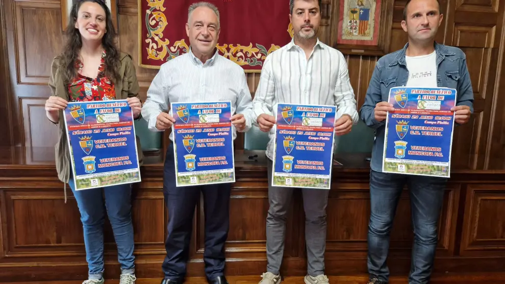 Los organizadores del partido de veteranos de Teruel posan con el cartel anunciador.