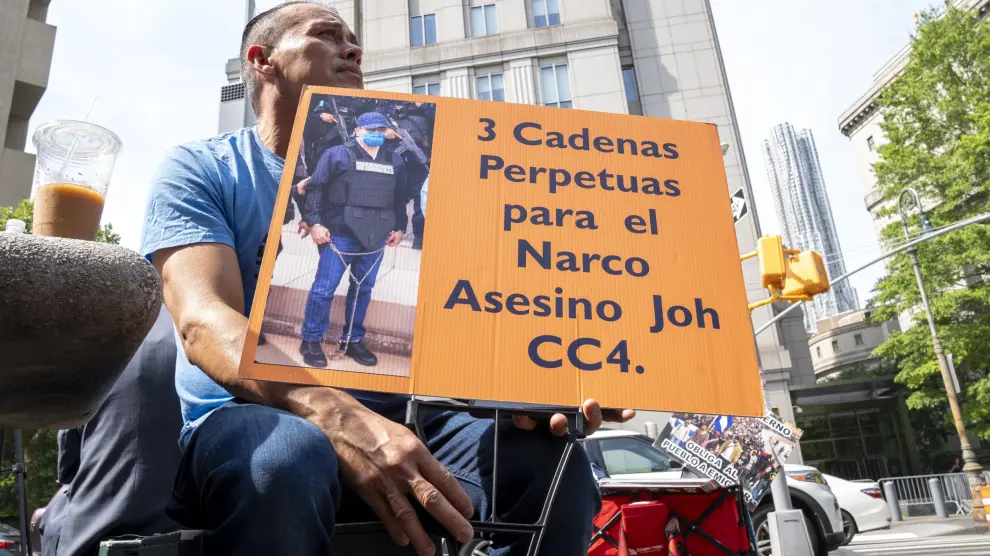 Un hombre sostiene una pancarta que pide "3 cadenas perpetuas al expresidente hondureño Juan Orlando Hernández" este miércoles, frente al tribunal federal de Manhattan en Nueva York