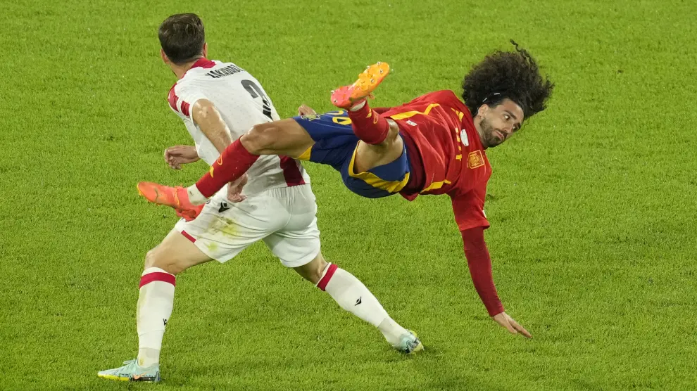 Georgia's Otar Kakabadze, left, challenges for the ball with Spain's Marc Cucurella during a round of sixteen match between Spain and Georgia at the Euro 2024 soccer tournament in Cologne, Germany, Sunday, June 30, 2024. (AP Photo/Andreea Alexandru)