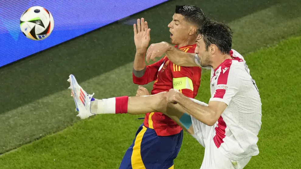 Georgia's Giorgi Gvelesiani, right, challenges for the ball with Spain's Alvaro Morata during a round of sixteen match between Spain and Georgia at the Euro 2024 soccer tournament in Cologne, Germany, Sunday, June 30, 2024. (AP Photo/Andreea Alexandru)