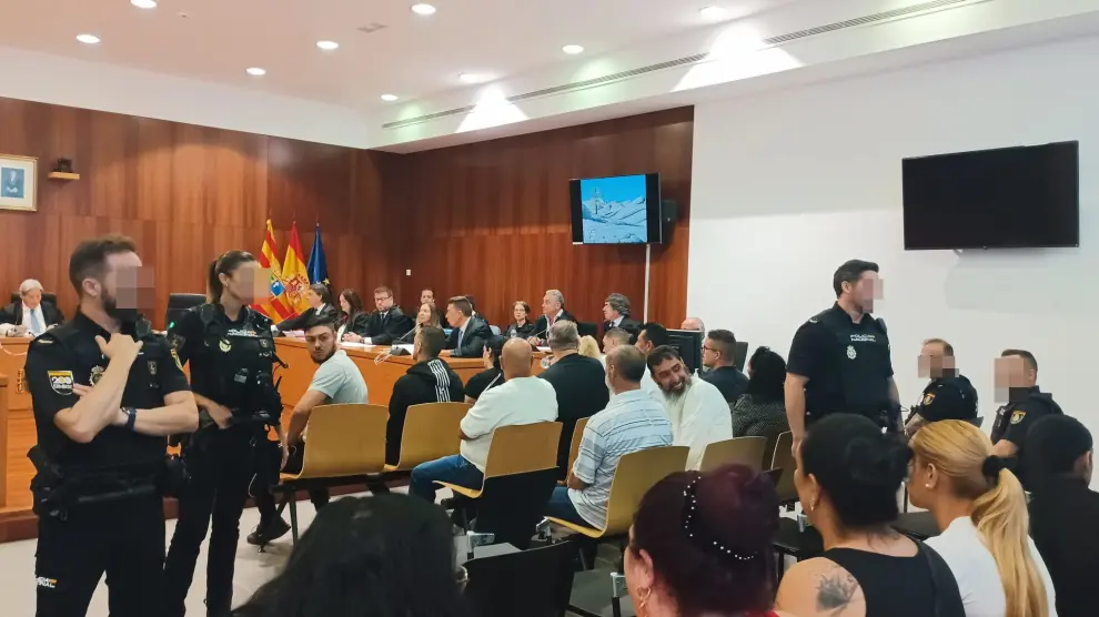 Los trece acusados, custodiados por la Policía Nacional, en la Audiencia de Zaragoza.