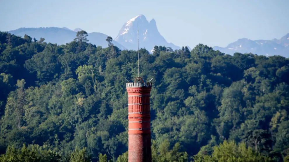 La chimenea de la antigua fábrica de tranvías permite divisar los picos que se extienden en la vista.