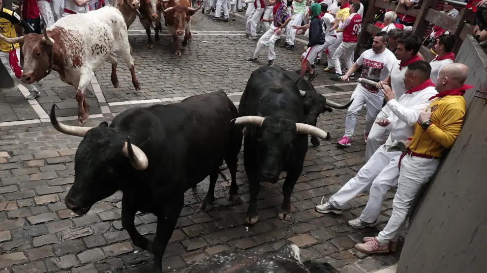 PAMPLONA, 09/07/2024.- Mozos son perseguidos por toros de Victoriano del Río en el tercer encierro de los Sanfermines este martes, en Pamplona. EFE/Jesús Diges ESPAÑA SANFERMINES ENCIERRO