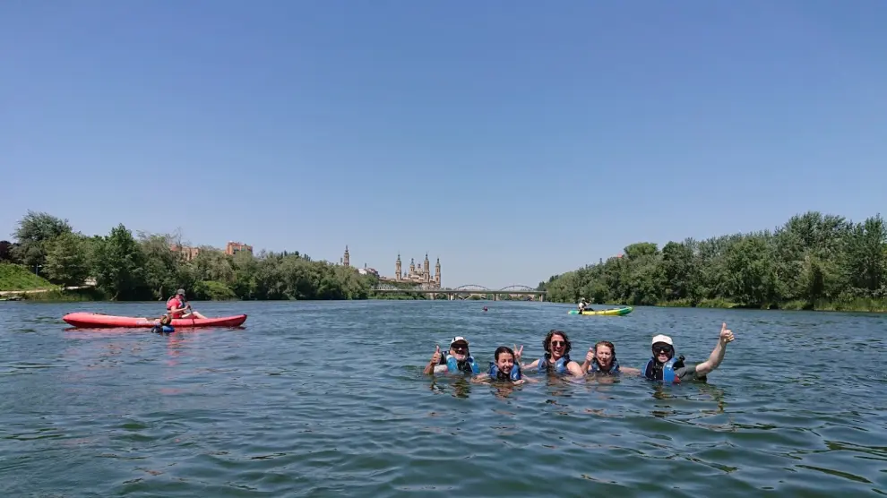 Un grupo de piraguistas se bañan en el Ebro al acabar su ruta por el barrio de Vadorrey.