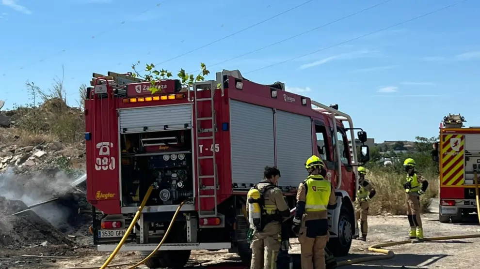Los bomberos trabajando en la extinción del incendio declarado en un almacén municipal de Cuarte.