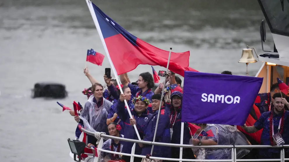 Samoa's Don Opeloge and Iuniarra Sipaia travel with teammates along the Seine River in Paris, France, during the opening ceremony of the 2024 Summer Olympics, Friday, July 26, 2024. (AP Photo/Kirsty Wigglesworth)