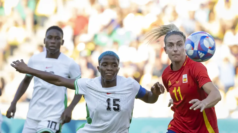 Nigeria's Rasheedat Ajibade, center, vies for the ball with Spain's Alexia Putellas during the women's Group C match between, Spain and Nigeria, at La Beaujoire Stadium, during the 2024 Summer Olympics Sunday, July 28, 2024, in Nantes, France. (AP Photo/Jeremias Gonzalez)