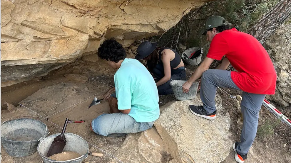 Los arqueólogos, excavando el suelo del abrigo de Pila Porquera, con pinturas rupestres en el techo.