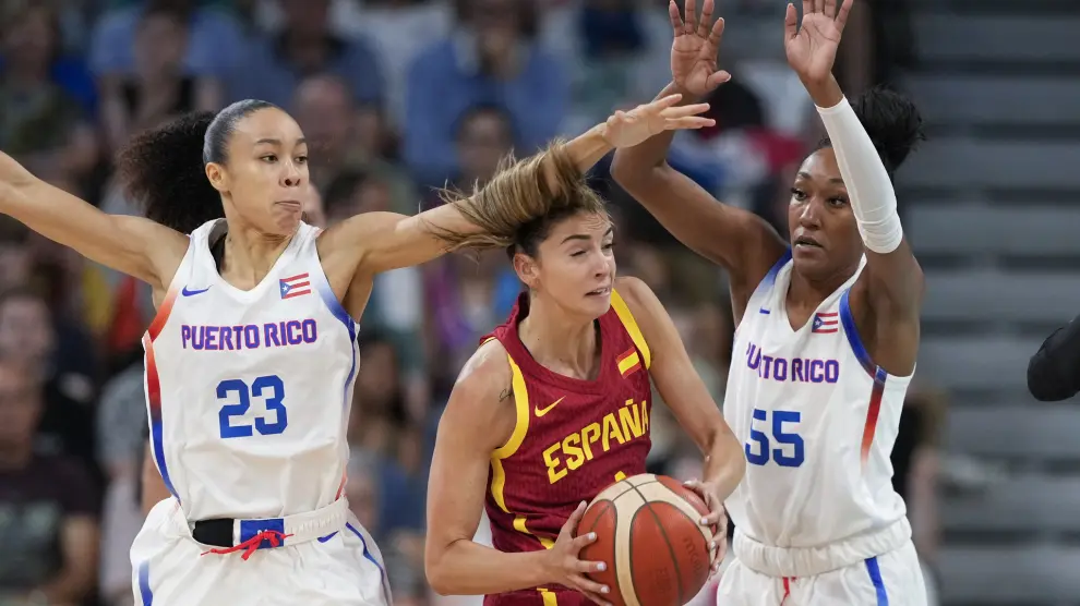 Mariona Ortiz, of Spain, gets trapped between Trinity San Antonio and Jacqueline Benitez, of Puerto Rico, in a women's basketball game at the 2024 Summer Olympics, Wednesday, July 31, 2024, in Villeneuve-d'Ascq, France. (AP Photo/Mark J. Terrill)
