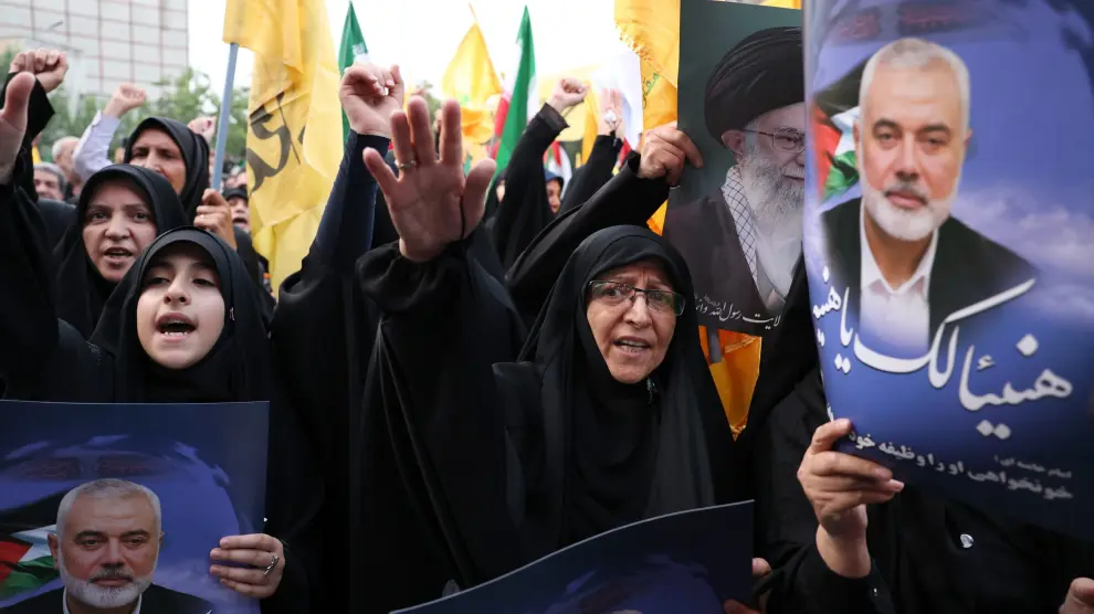 Iraníes alzan imágenes del líder de Hamás Ismail Haniyeh en su funeral.