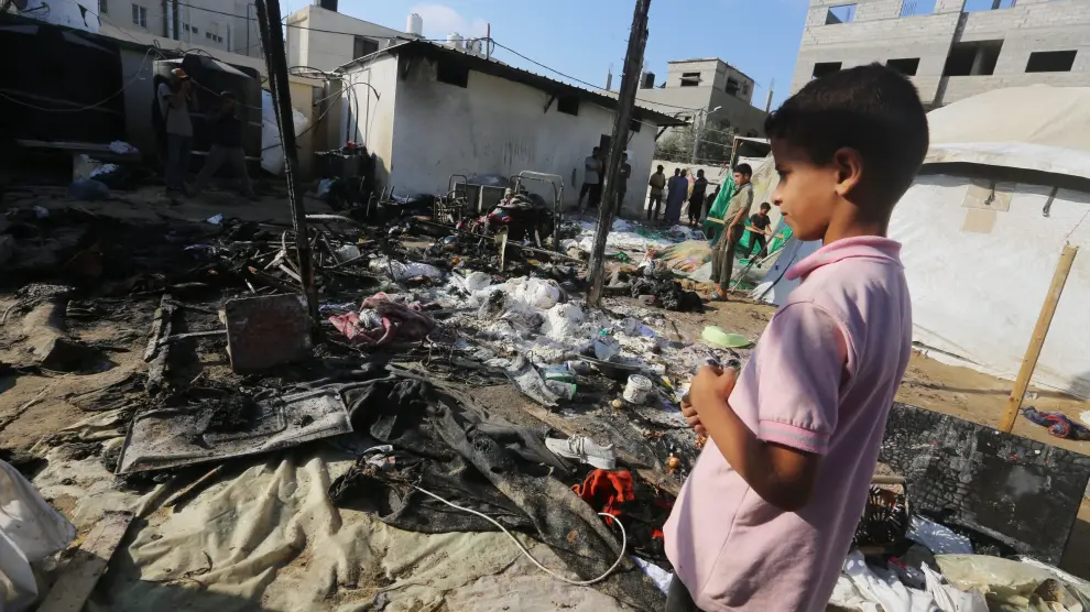 Un niño palestino junto a una escuela derribada