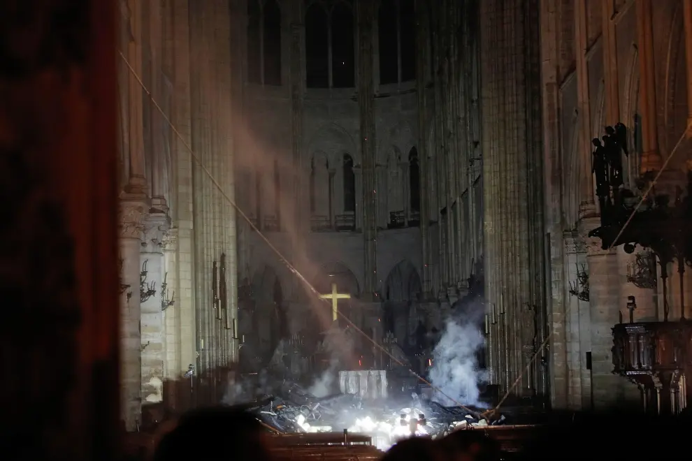 Smoke rises around the altar in front of the cross inside the Notre Dame Cathedral as a fire continues to burn in Paris, France, April 16, 2019.   REUTERS/Philippe Wojazer/Pool     TPX IMAGES OF THE DAY [[[REUTERS VOCENTO]]] FRANCE-NOTREDAME/