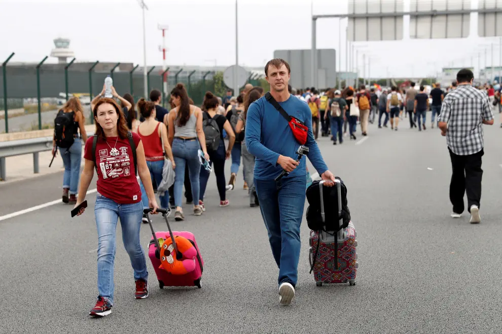 Dos pasajeros llegan caminando al aeropuerto del Prat.