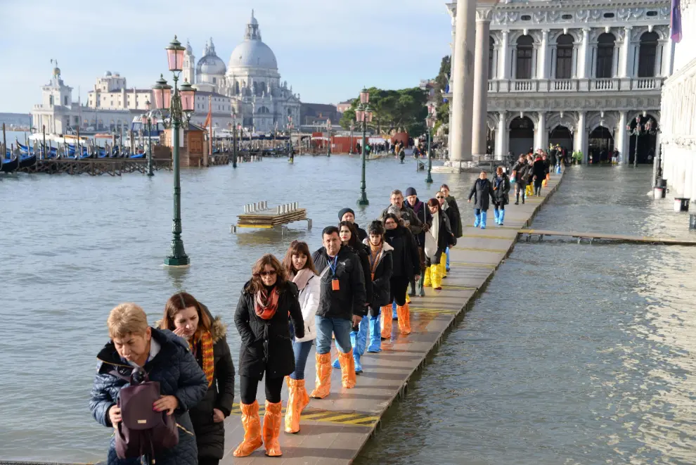 Venice (Italy), 23/12/2019.- A group of tourists walks in single file along a walkway, on the San Marco pier flooded by high tide, Venice, Italy, 23 December 2019. The high tide reached 144 cm. (Italia, Niza, Venecia) EFE/EPA/Andrea Merola High waters in Venice