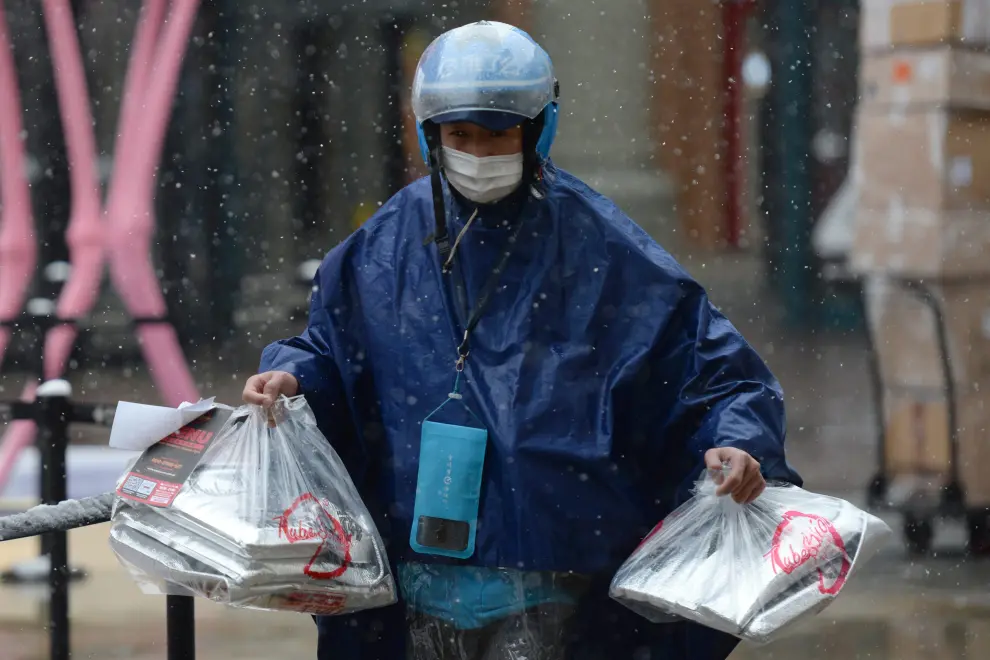 Un repartidor de comida a domicilio lleva varios pedidos para el Día de San Valentín, en Pekín.