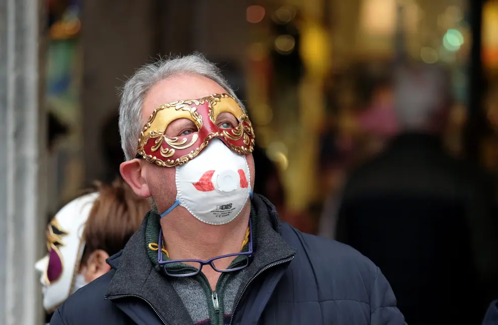 A masked carnival reveller wears protective face mask at Venice Carnival, which the last two days of, as well as Sunday night's festivities, have been cancelled because of an outbreak of coronavirus, in Venice, Italy February 23, 2020. REUTERS/Manuel Silvestri [[[REUTERS VOCENTO]]] CHINA-HEALTH/ITALY-VENICE