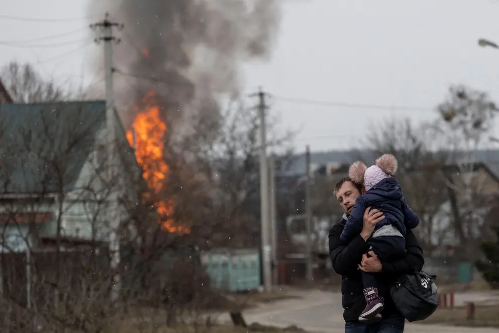 Un hombre con su hija huye de los bombardeos sobre la ciudad ucraniana de Irvin