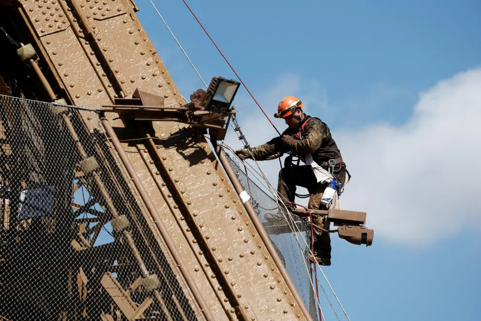 Workers work on the Eiffel tower during the 20th campaign of painting and stripping in Paris, France, July 5, 2022. REUTERS/Benoit Tessier FRANCE-EIFFEL/RUST