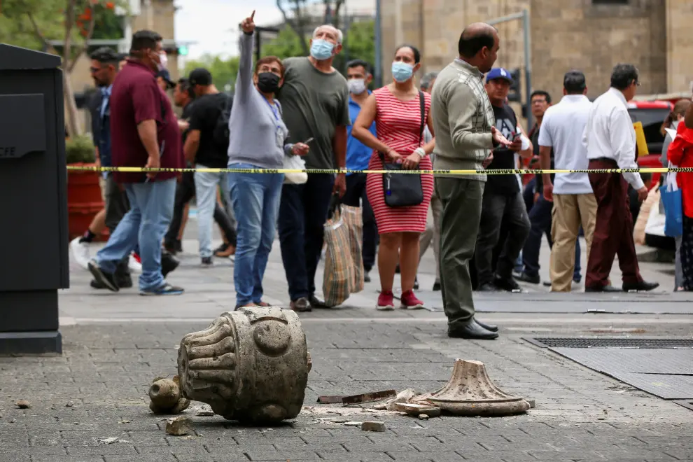 A woman reacts after rocks that fell off a church hit her car during an earthquake, in Guadalajara, Mexico September 19, 2022. REUTERS/Fernando Carranza MEXICO-QUAKE/