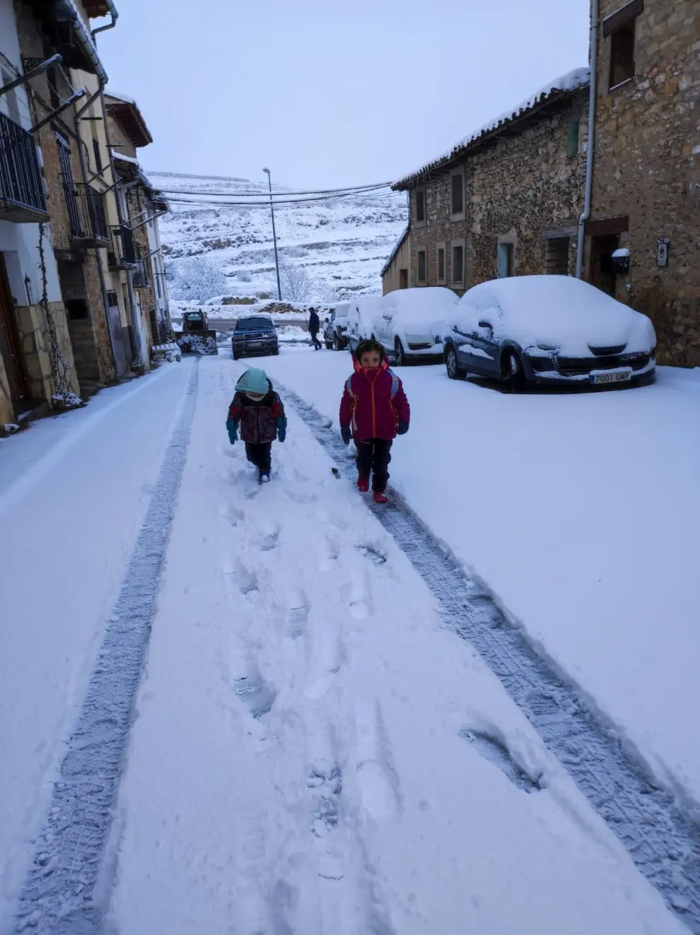 Dos niños se dirigen al colegio en Mosqueruela en medio de la nevada,