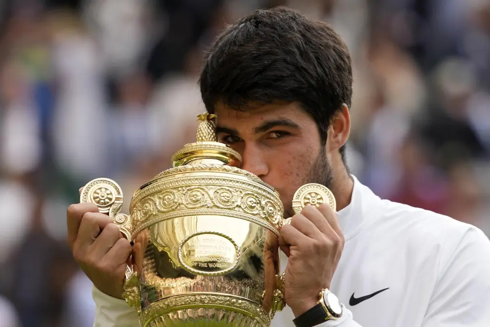 Spain's Carlos Alcaraz celebrates with the trophy after beating Serbia's Novak Djokovic to win the final of the men's singles on day fourteen of the Wimbledon tennis championships in London, Sunday, July 16, 2023. (AP Photo/Kirsty Wigglesworth)