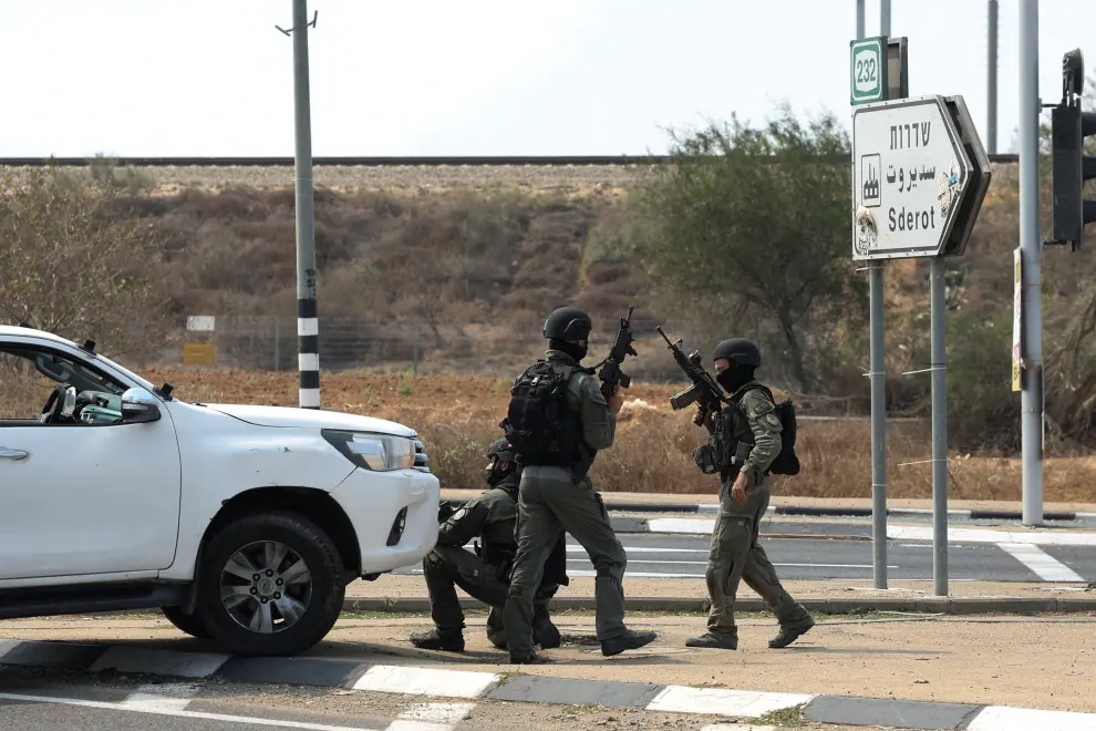 Israeli security take position as a car approaches on a road following a mass infiltration by Hamas gunmen from the Gaza Strip, near Sderot in southern Israel October 8, 2023. REUTERS/Ronen Zvulun ISRAEL-PALESTINIANS/
